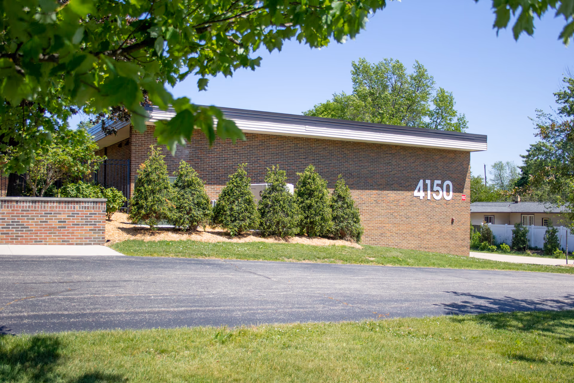 Exterior view of a brick senior living building with landscaping and the number 4150.
