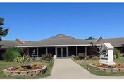 Front view of Meadows Manor East senior living facility with landscaped entry and walkway