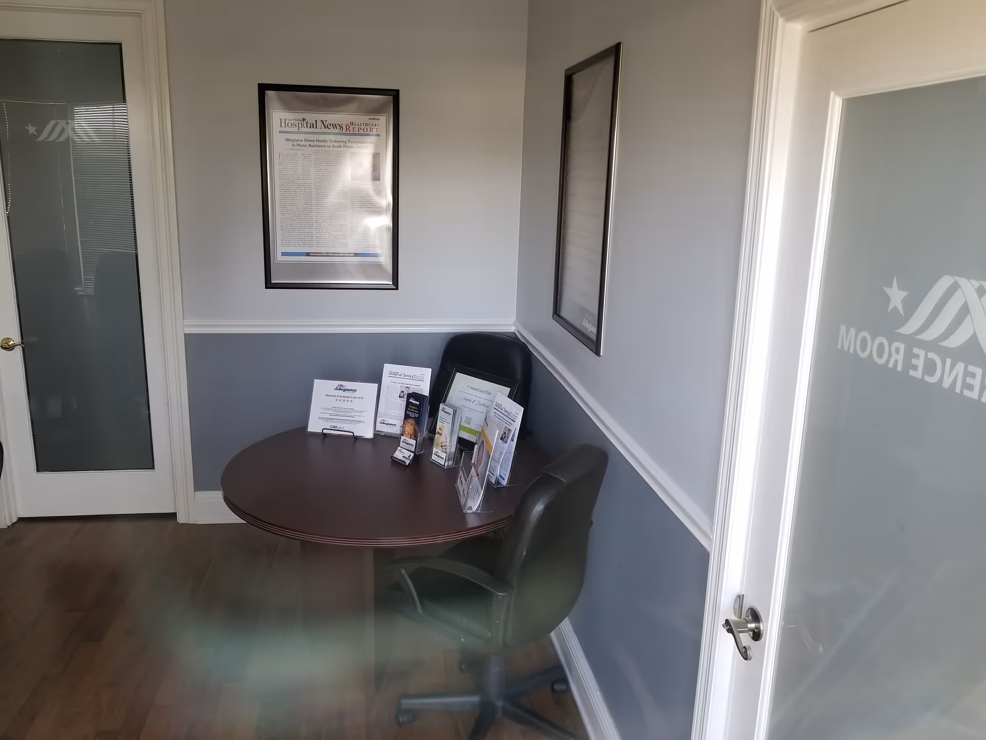 Round table with brochures and a chair inside a small interior consultation area.