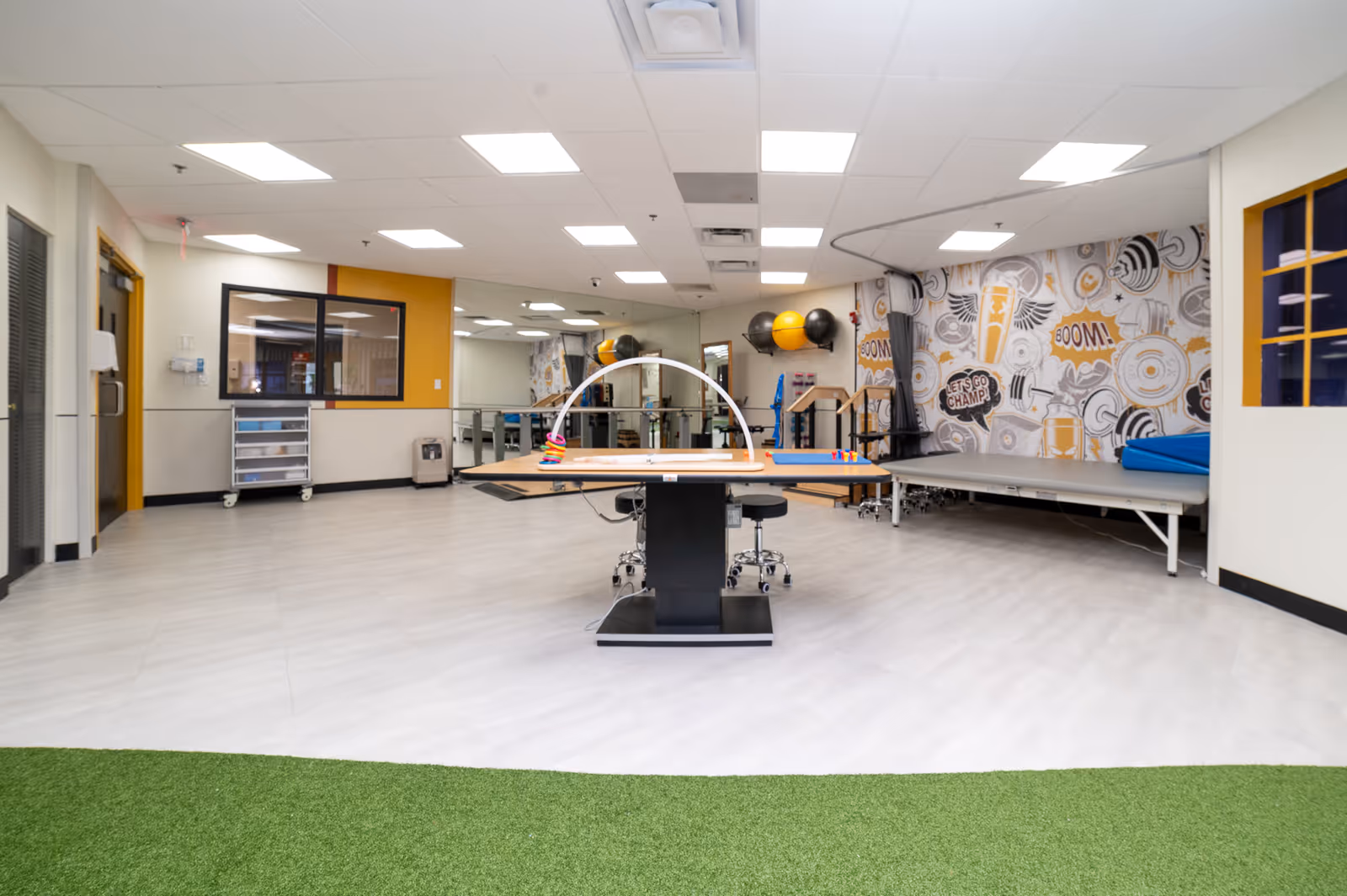 Interior rehab therapy room featuring a central table and exercise equipment.