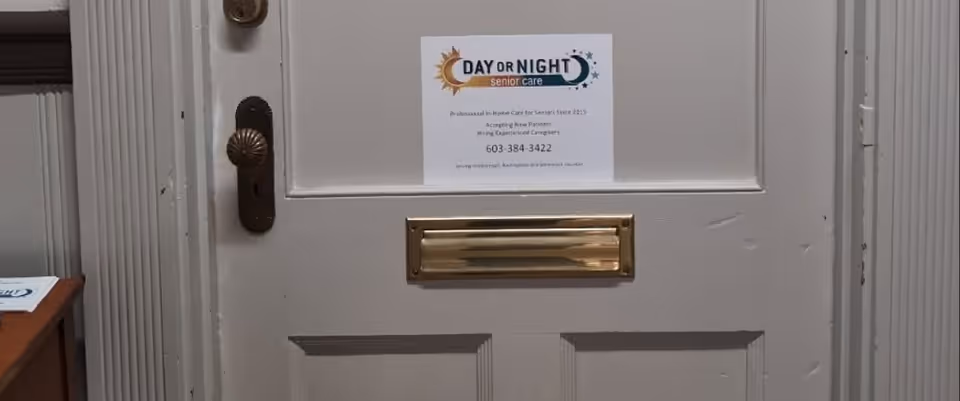 Close-up of an entry door with a posted Day or Night senior care sign.