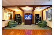 Interior lounge area with two green armchairs, bookshelves, and a central aquarium.