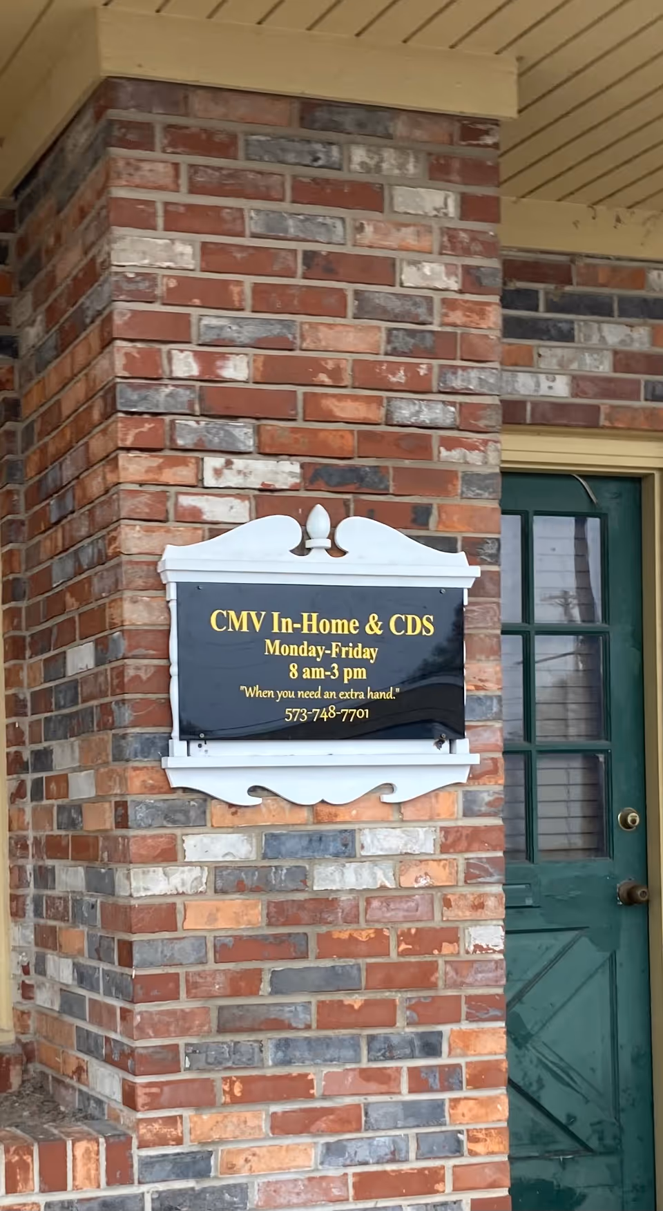 Brick exterior with CMV In-Home & CDS sign beside a green front door.