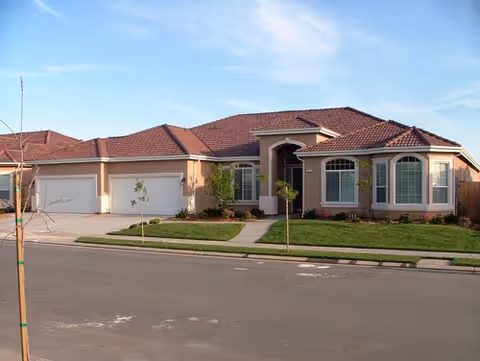 Front view of a single-story residential-style senior living facility with a red-tiled roof.