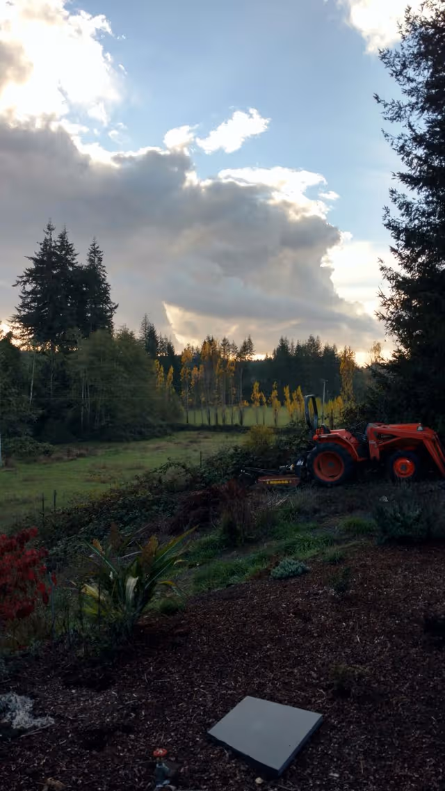 Exterior garden area of Country Gardens Senior Residence with a tractor and trees.
