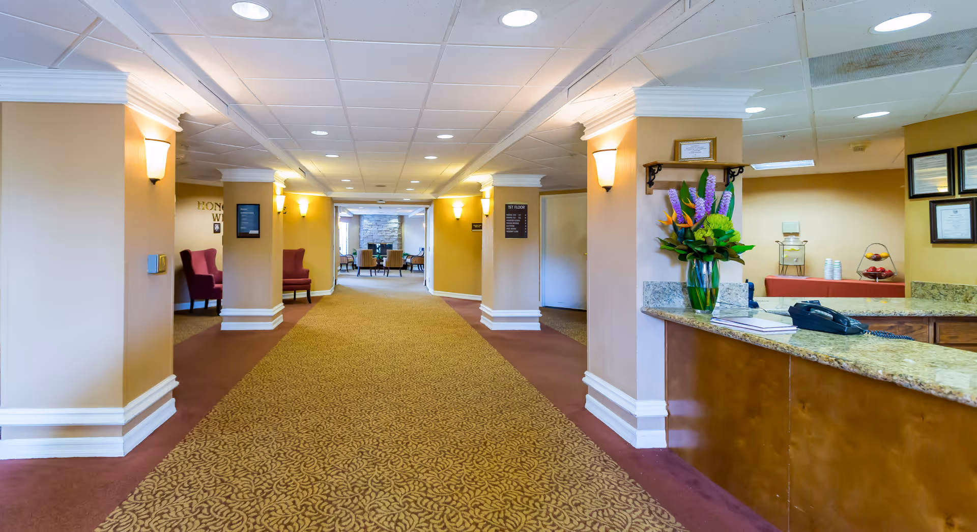 Bright interior hallway of a Brookdale Senior Living community with a front desk.