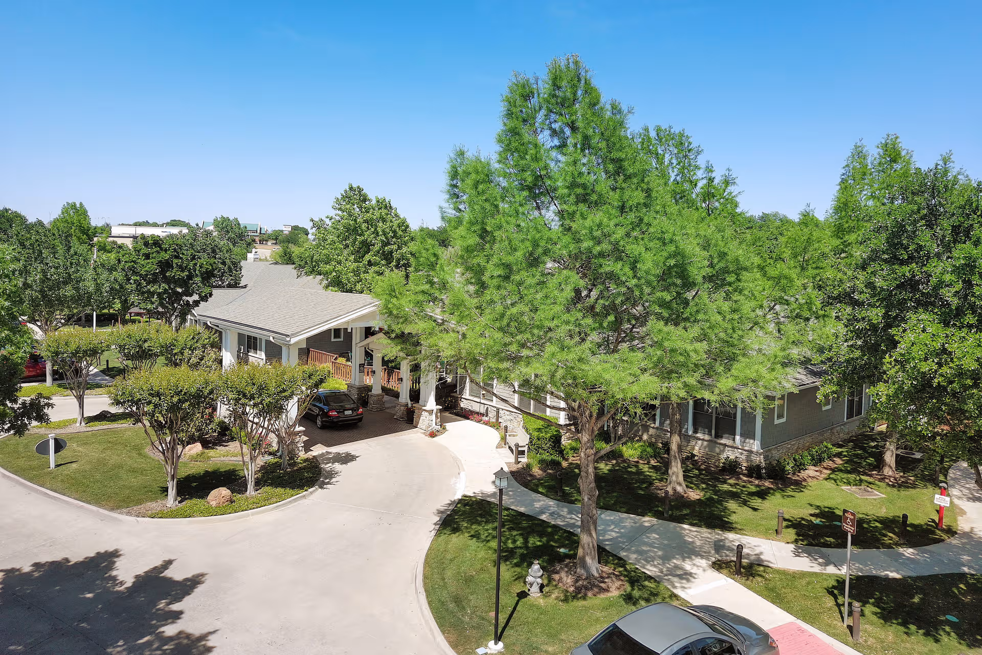 Aerial view of Sunrise of Fort Worth exterior showing curved drive, entrance, and trees.
