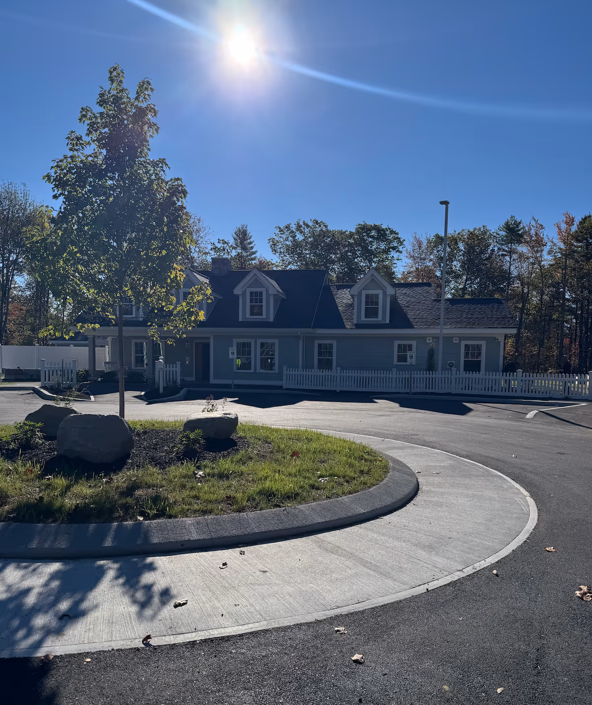 Sunny view of The Mooring of Kennebunk building with circular driveway and landscaping.