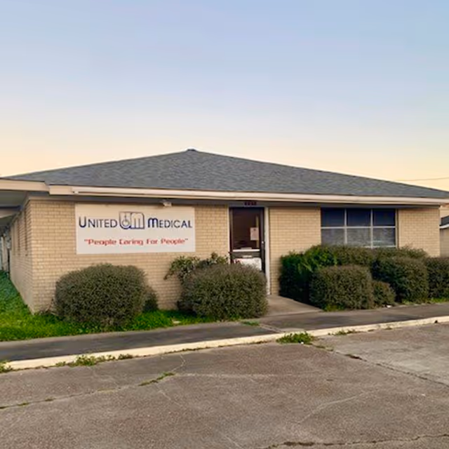 A single-story brick building with a United Medical sign and trimmed shrubs in front.