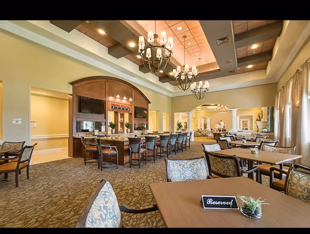 Spacious dining hall inside Elm Tree Lodge with tables and a central service bar.