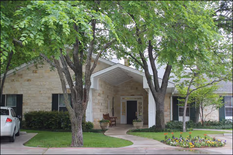Front entrance of Gemstone Senior Living at Riverpark with trees and landscaping