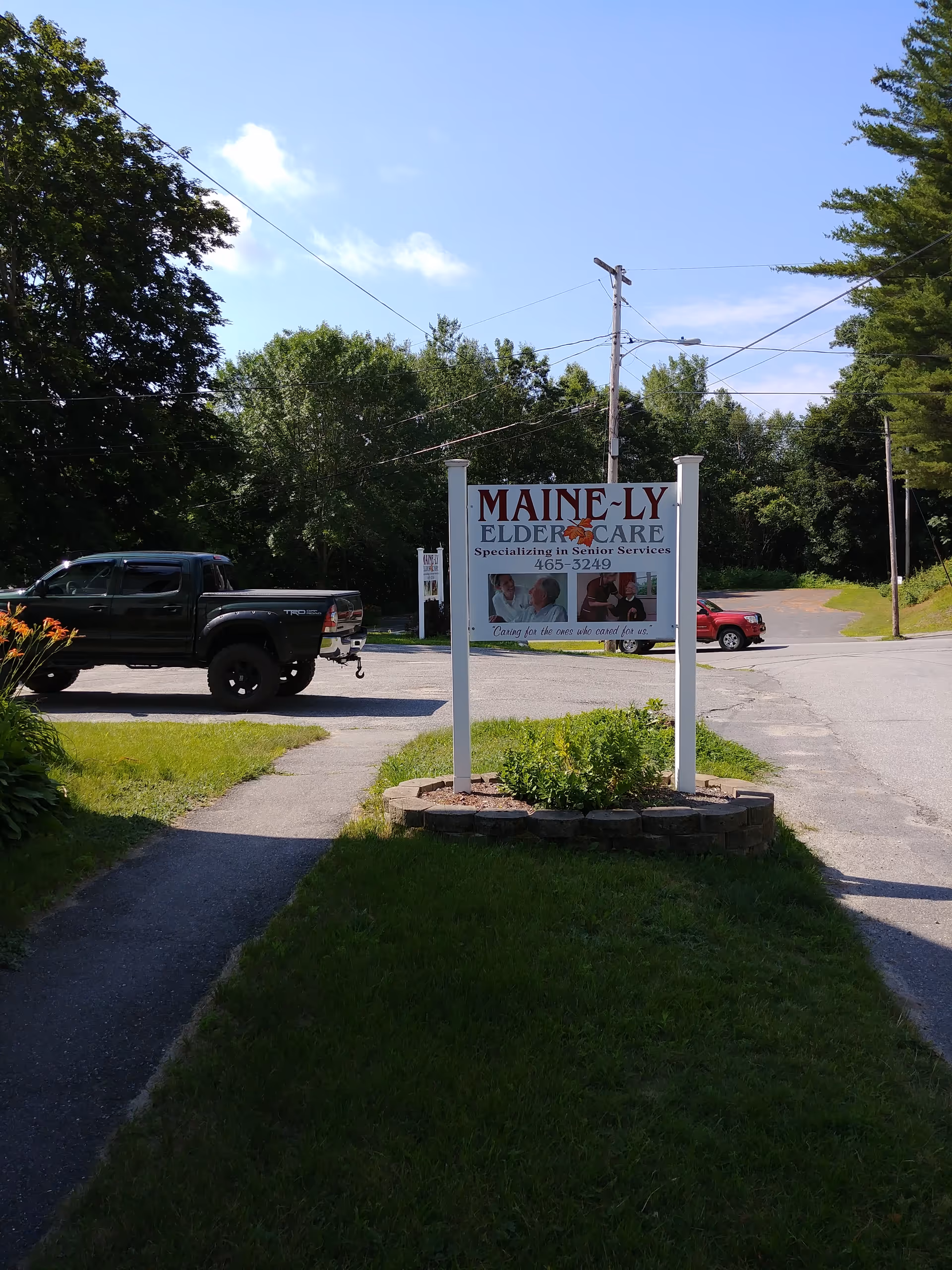 Maine-ly Elder Care sign on a grassy median beside a parking lot.