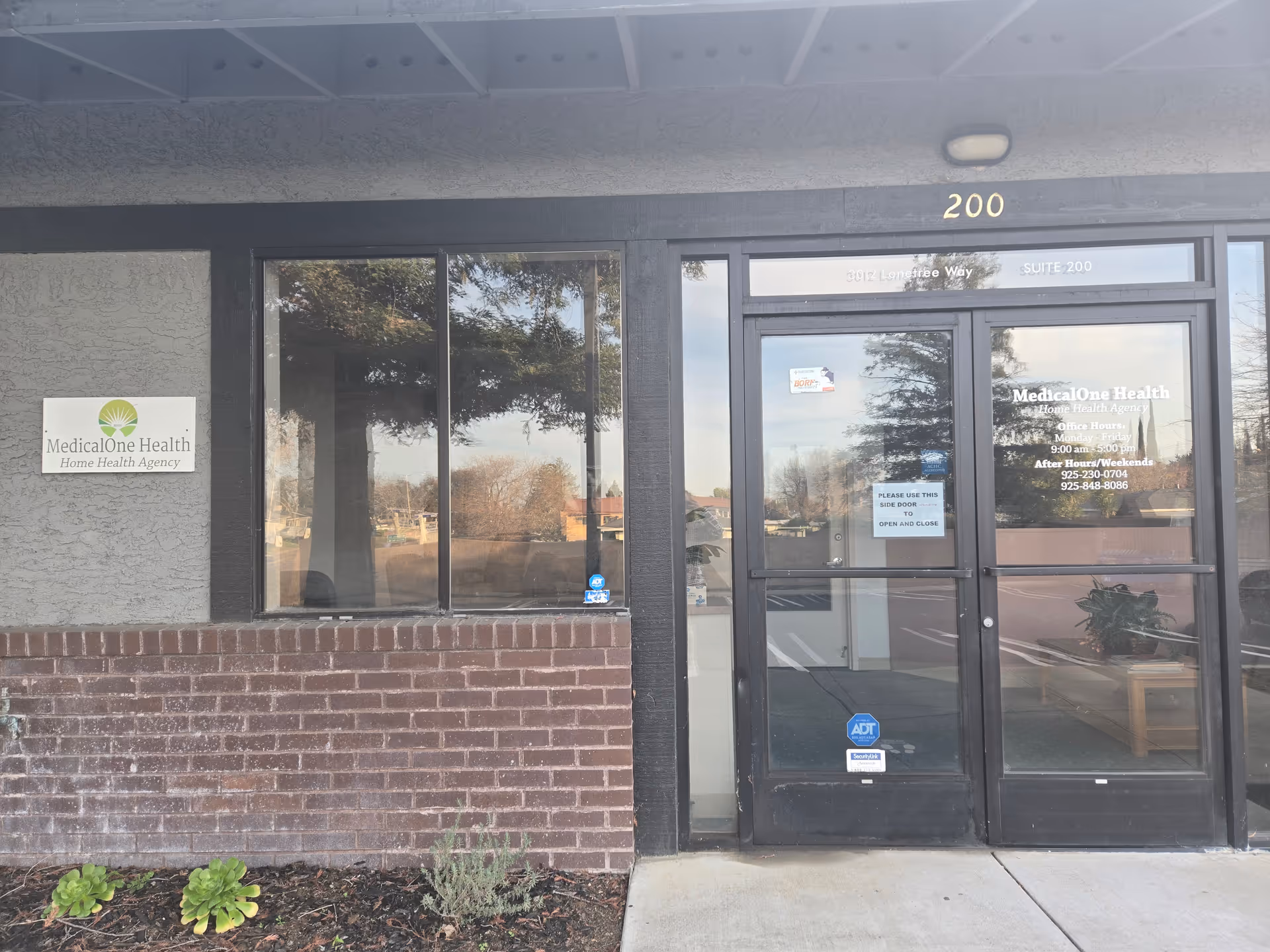 Exterior view of MedicalOne Health LLC building entrance with sign and glass doors.