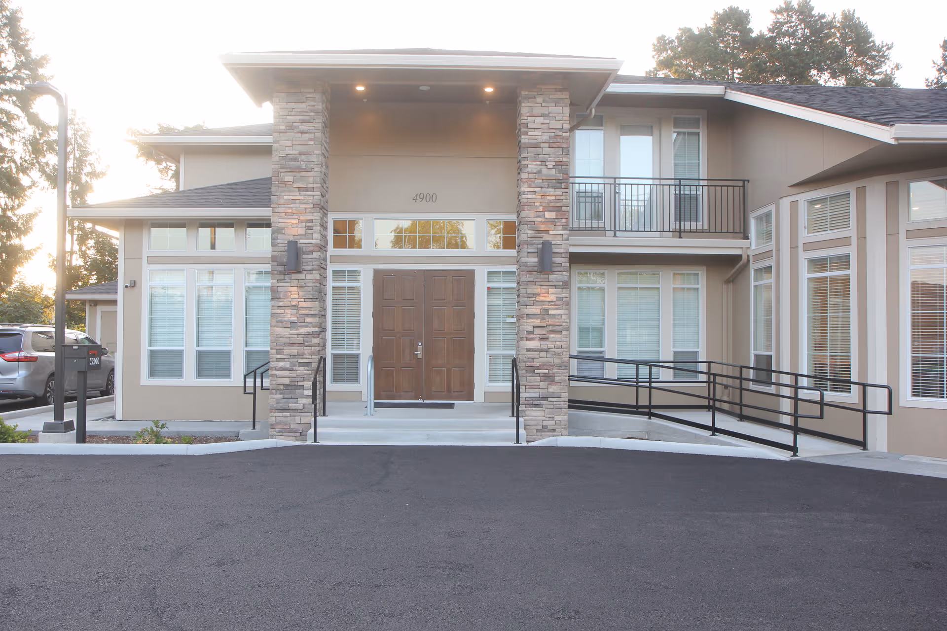 Front entrance of Murray Highland Memory Care with stone pillars and a ramp
