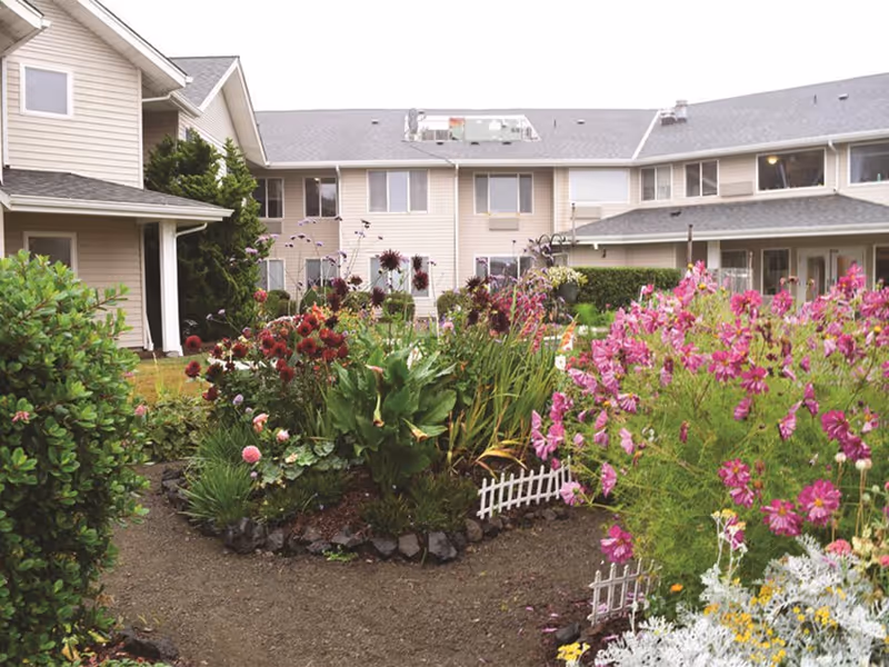 Exterior view of Oceanview Assisted Living Residence courtyard with vibrant flower garden.