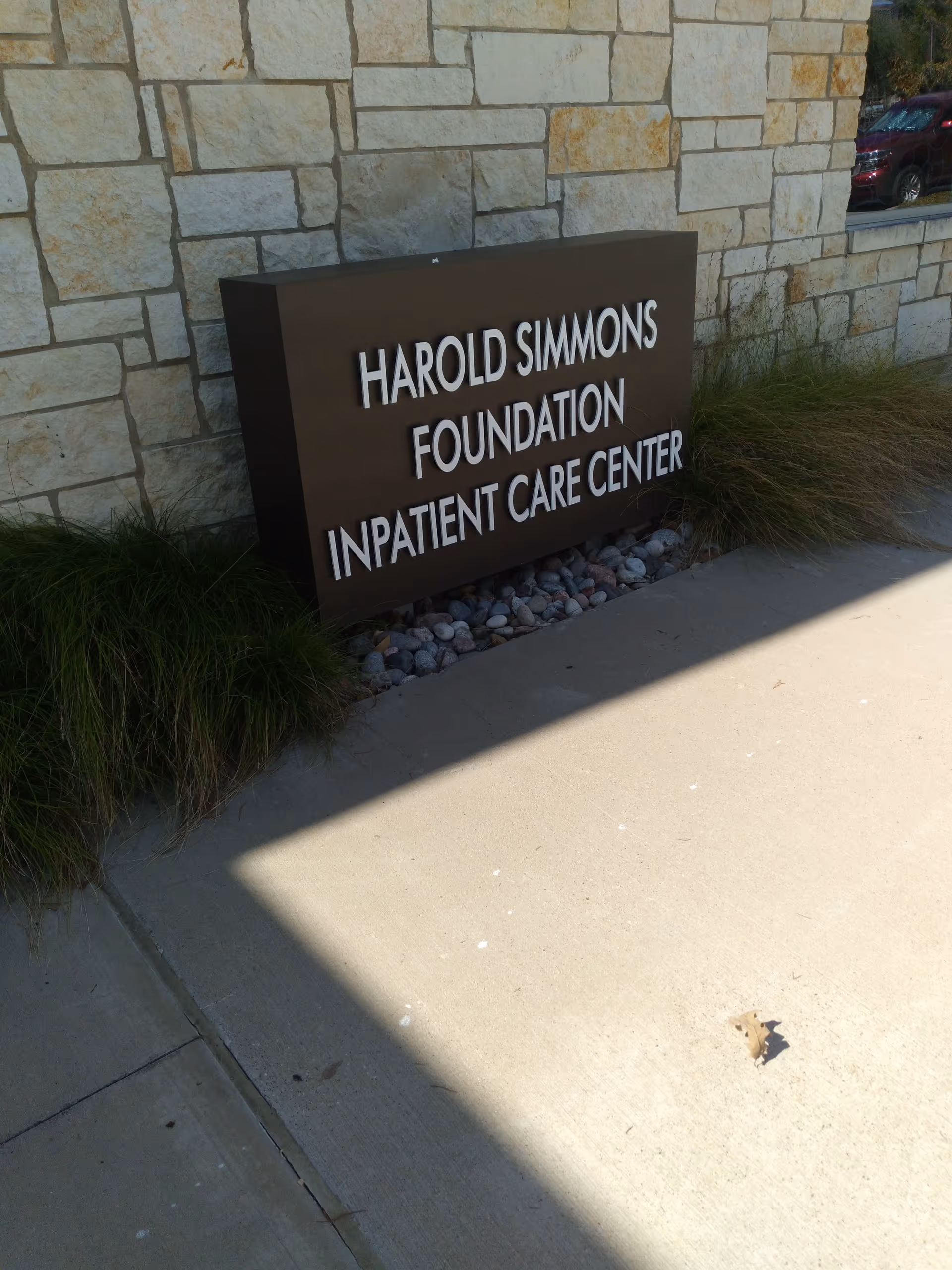 Stone exterior wall with a large sign reading Harold Simmons Foundation Inpatient Care Center.