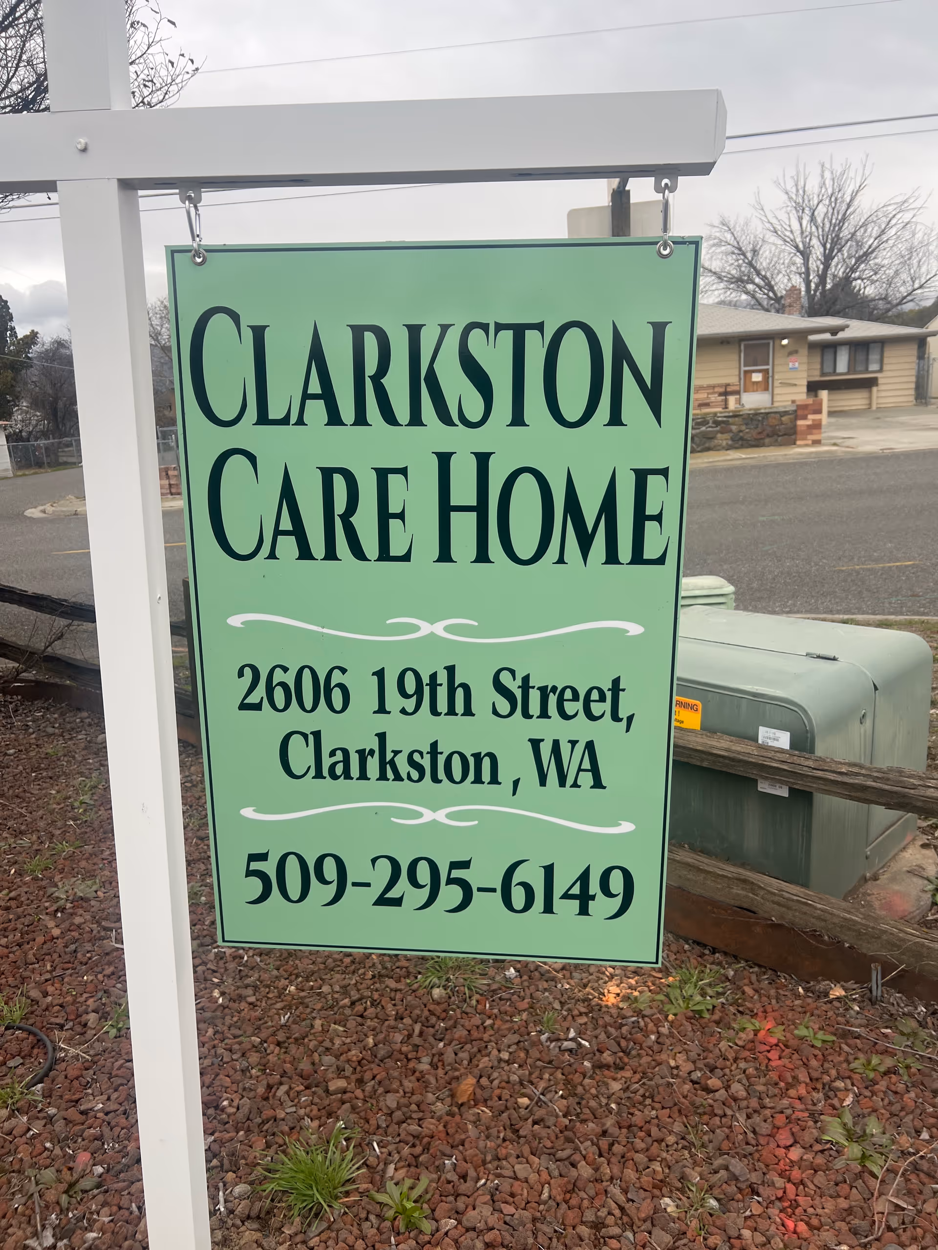 Green Clarkston Care Home sign with address and phone on exterior post