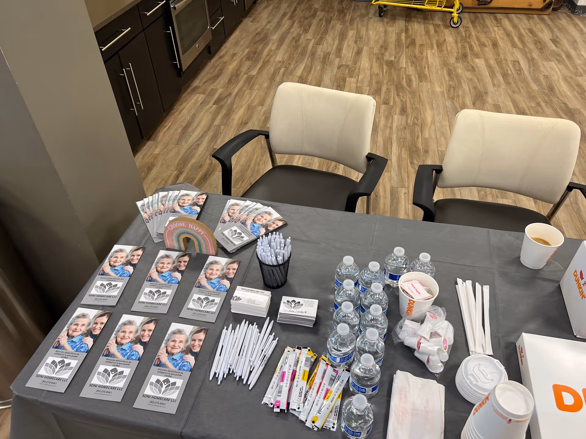 Registration table with brochures, pens, and bottled water in a facility lobby.
