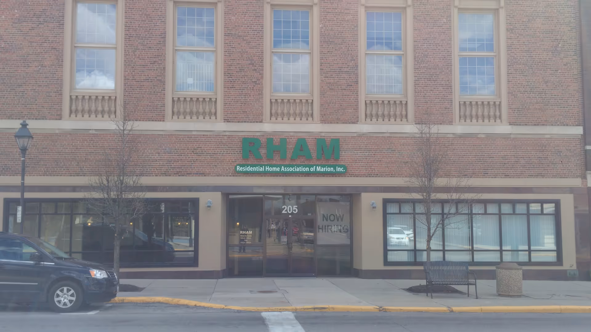 Brick building front of a senior living facility with RHAM sign and entrance.