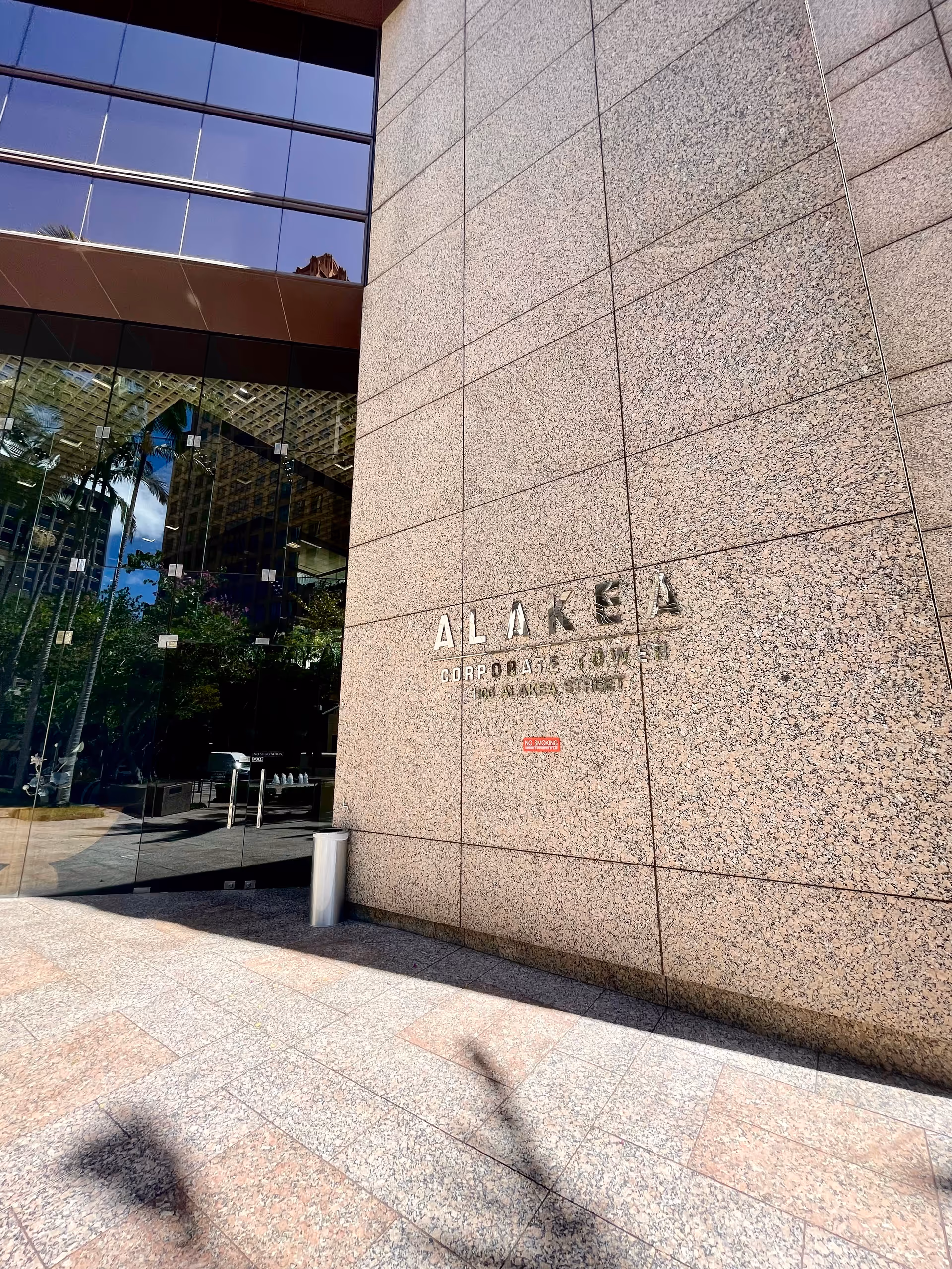 Front entrance of a modern granite-clad building with glass doors.