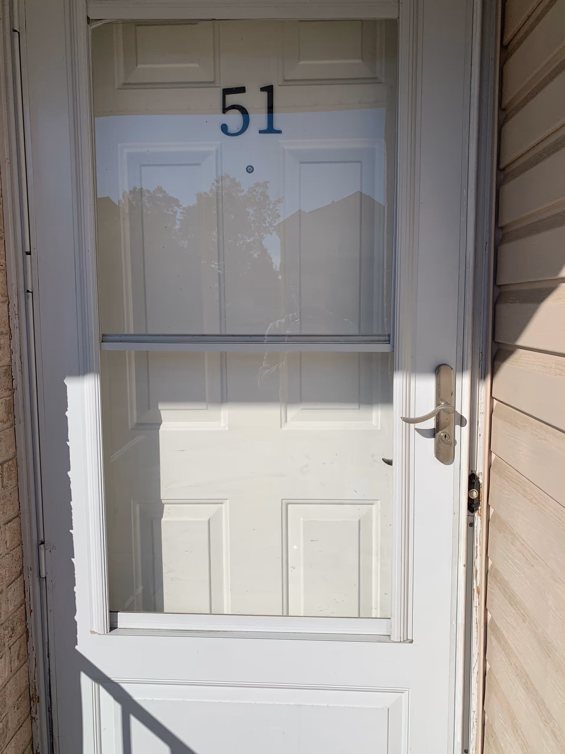 White exterior door with the number 51 and a glass window panel.