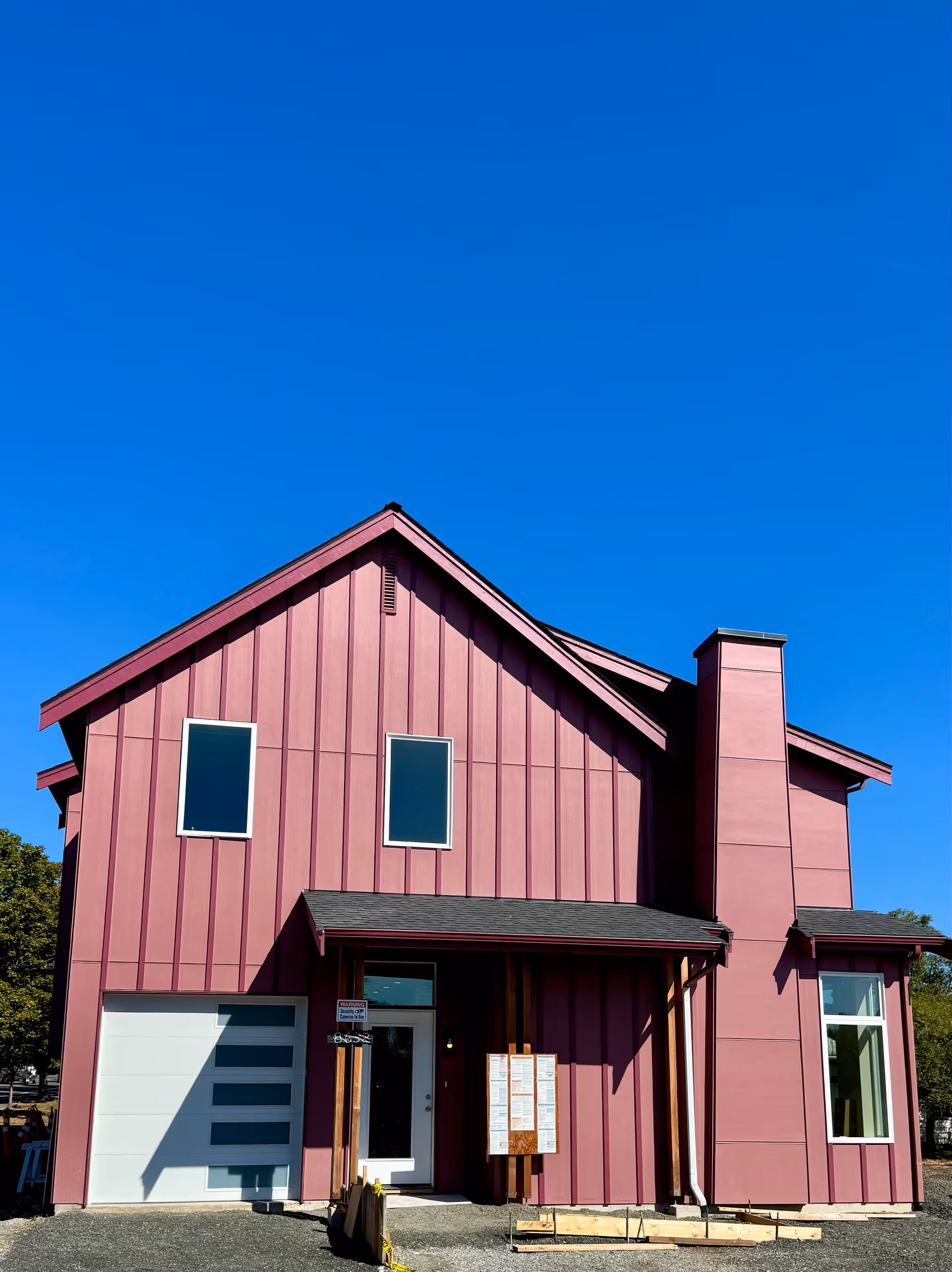 Front view of a pink, modern facility building with a small entry.