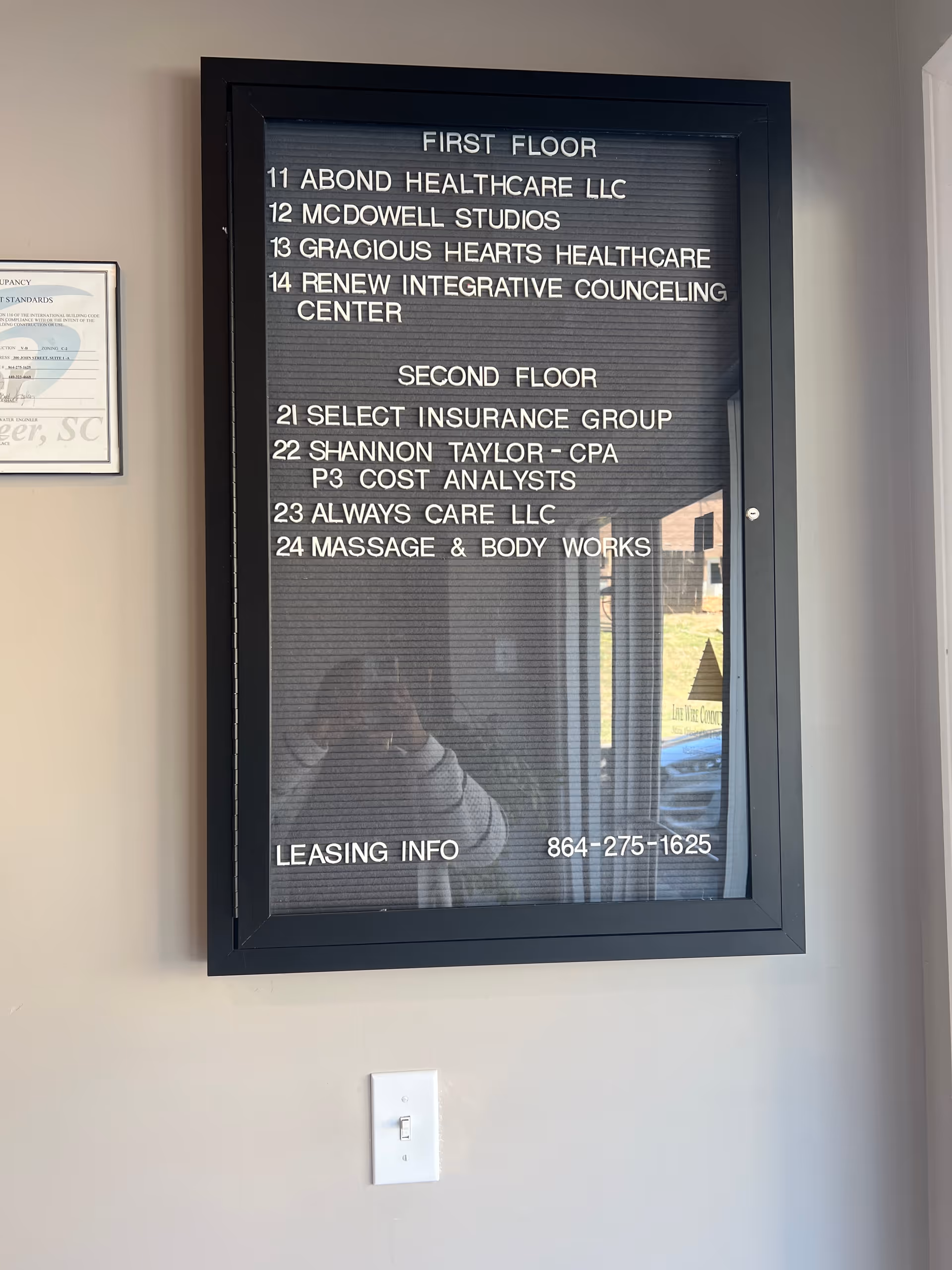 Framed directory sign on wall listing offices and floors inside a senior facility.