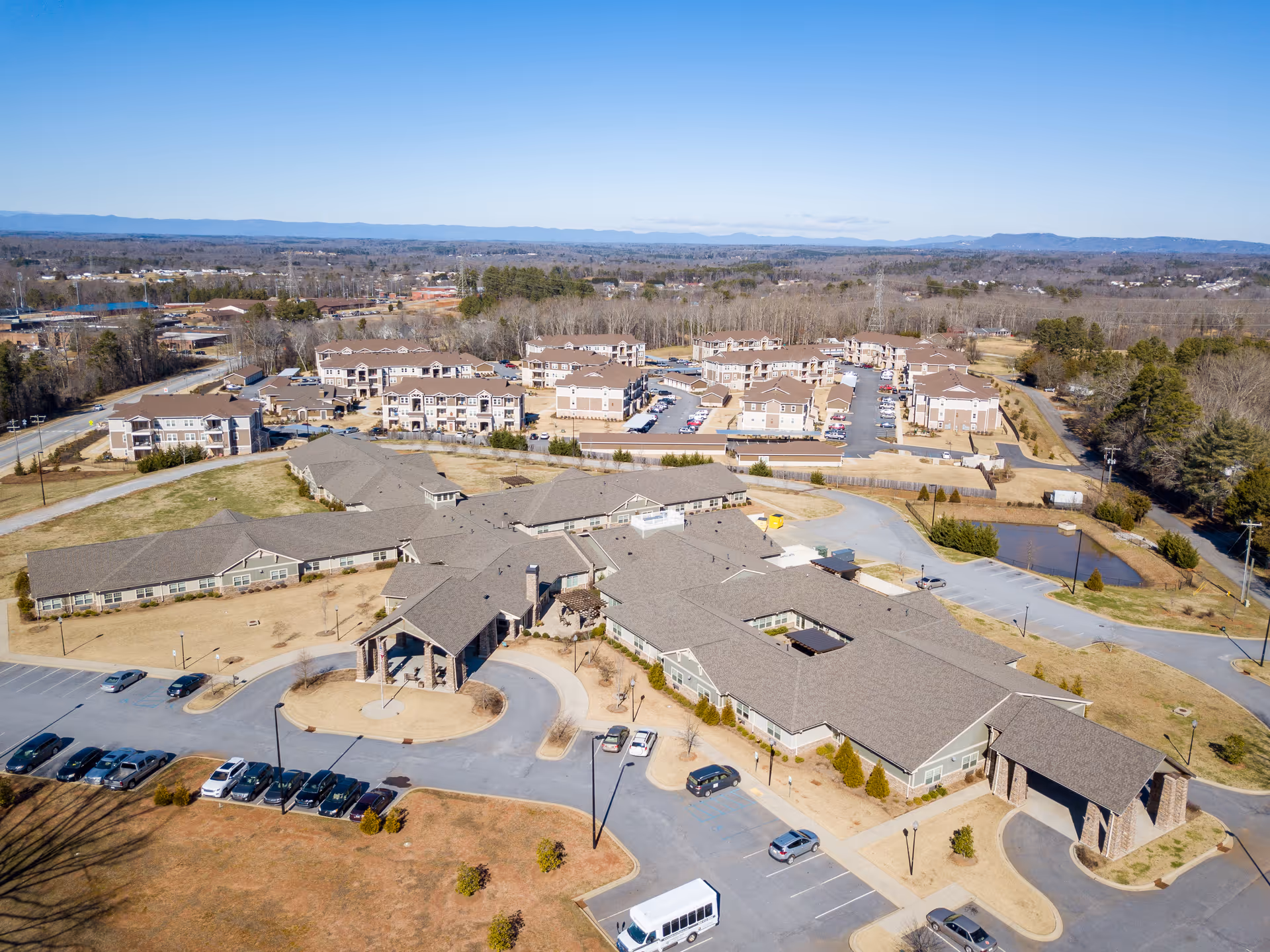 Aerial view of Oakview Park senior living campus showing multiple low-rise buildings, parking lots, and surrounding landscape.