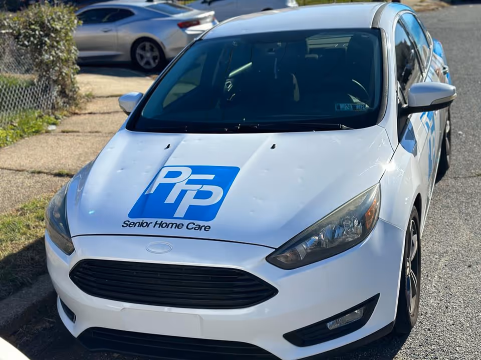 White sedan with PFP Senior Home Care logo parked in a lot