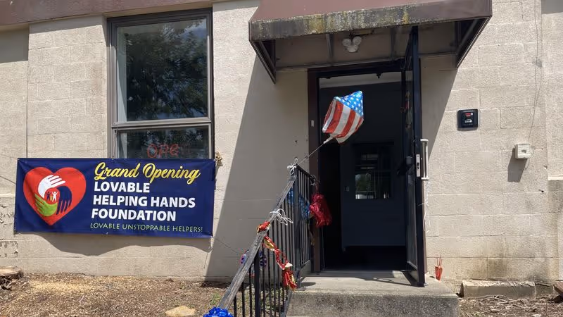 Exterior entrance with a blue banner and American flag at Lovable Helping Hands Foundation.