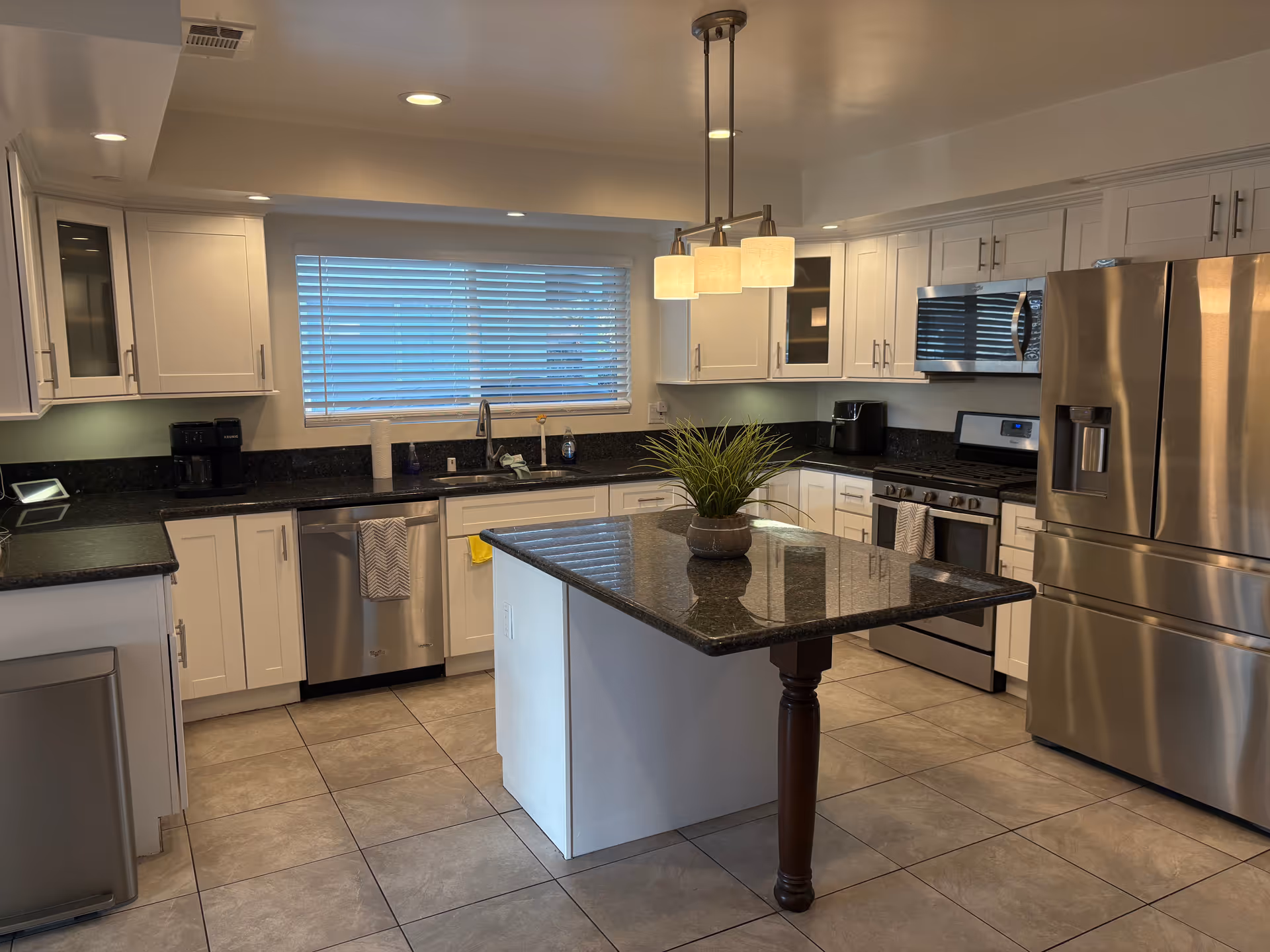 Bright, modern kitchen with stainless appliances, white cabinets, and central island.
