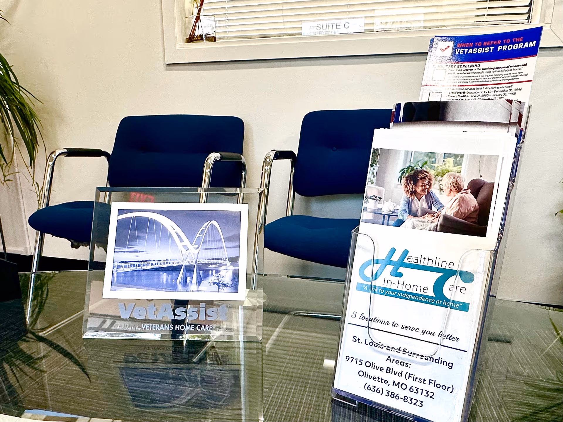 Interior waiting area featuring blue chairs, a glass coffee table, and Healthline In-Home Care brochures.