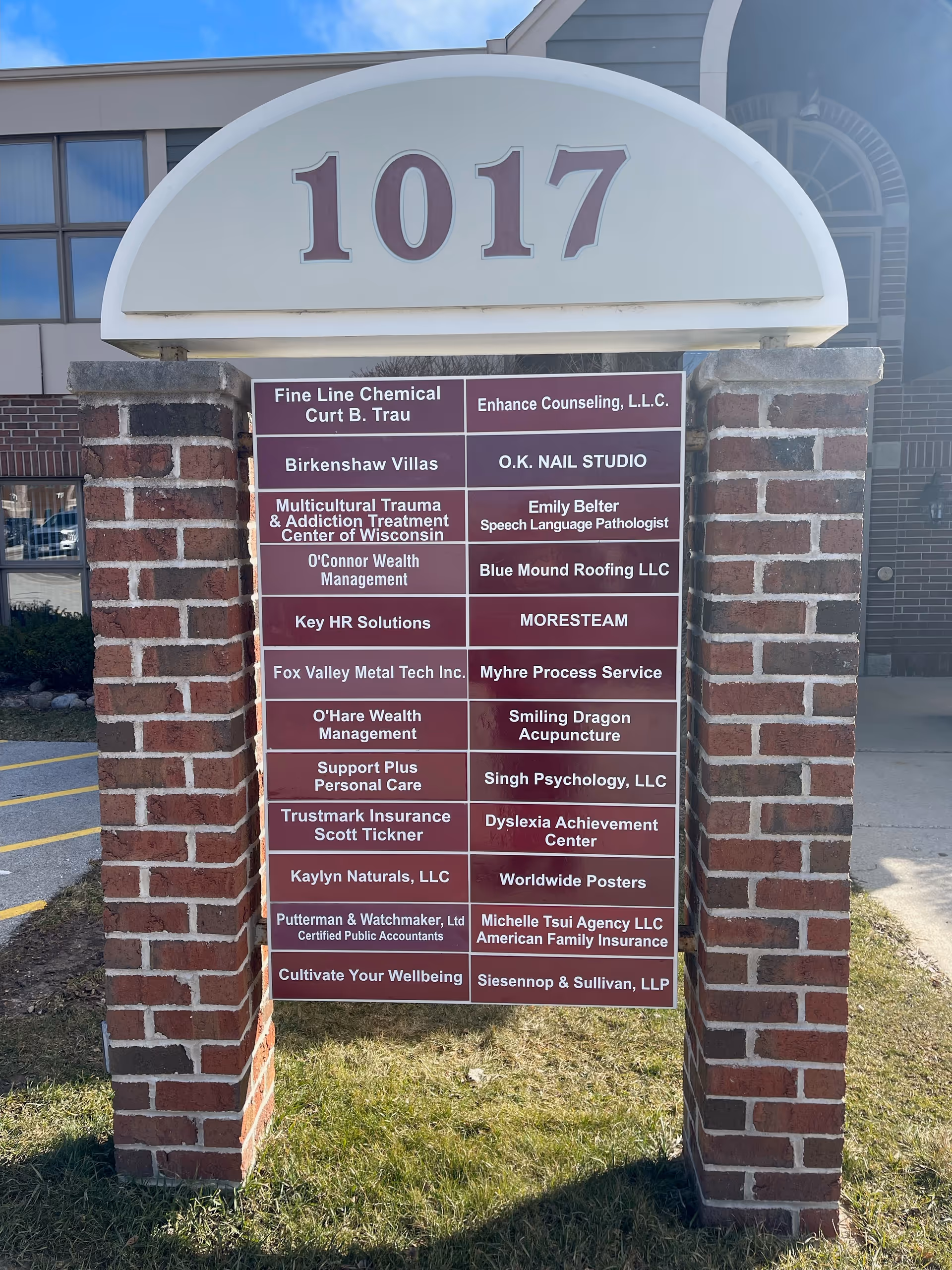 Exterior brick sign with 1017 and a multi-tenant directory board.