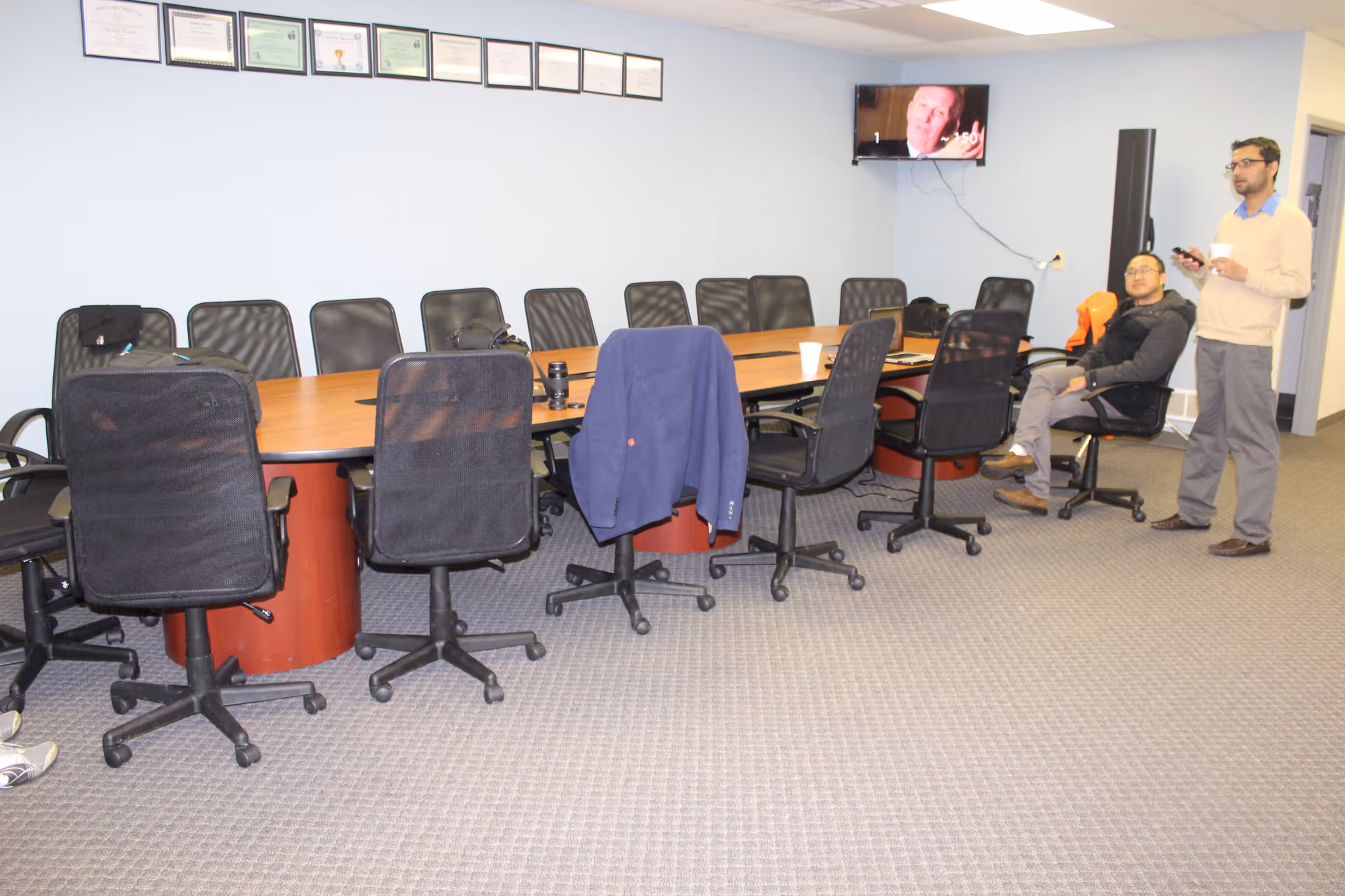 Ideal Homecare Agency conference room with long table, many chairs, and two men nearby.