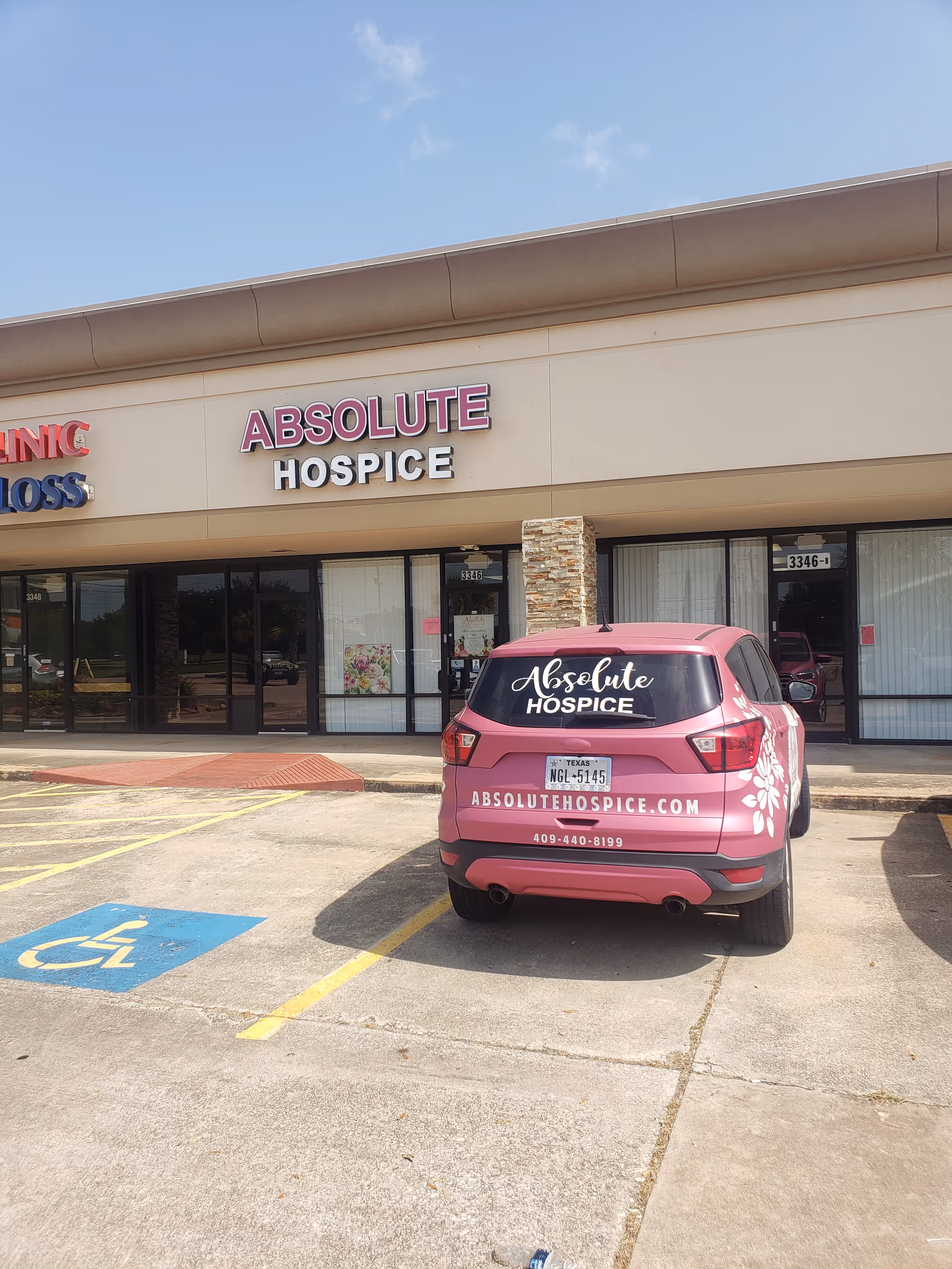 Absolute Hospice storefront with a pink promotional vehicle parked in front.