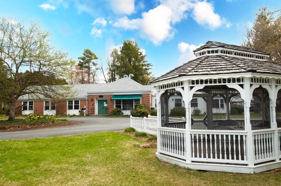 Hospice of the Fisher Home facility with brick building and white gazebo outdoors.