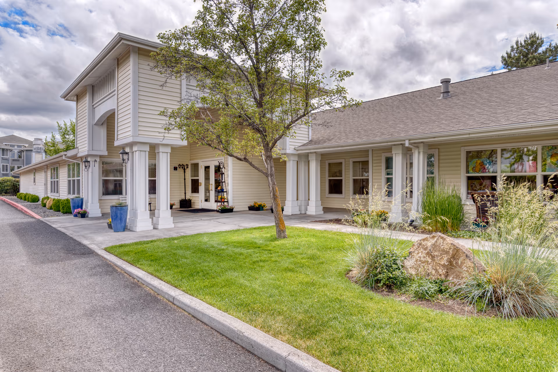 Front of Awbrey Place assisted living building with entrance and landscaped grounds.