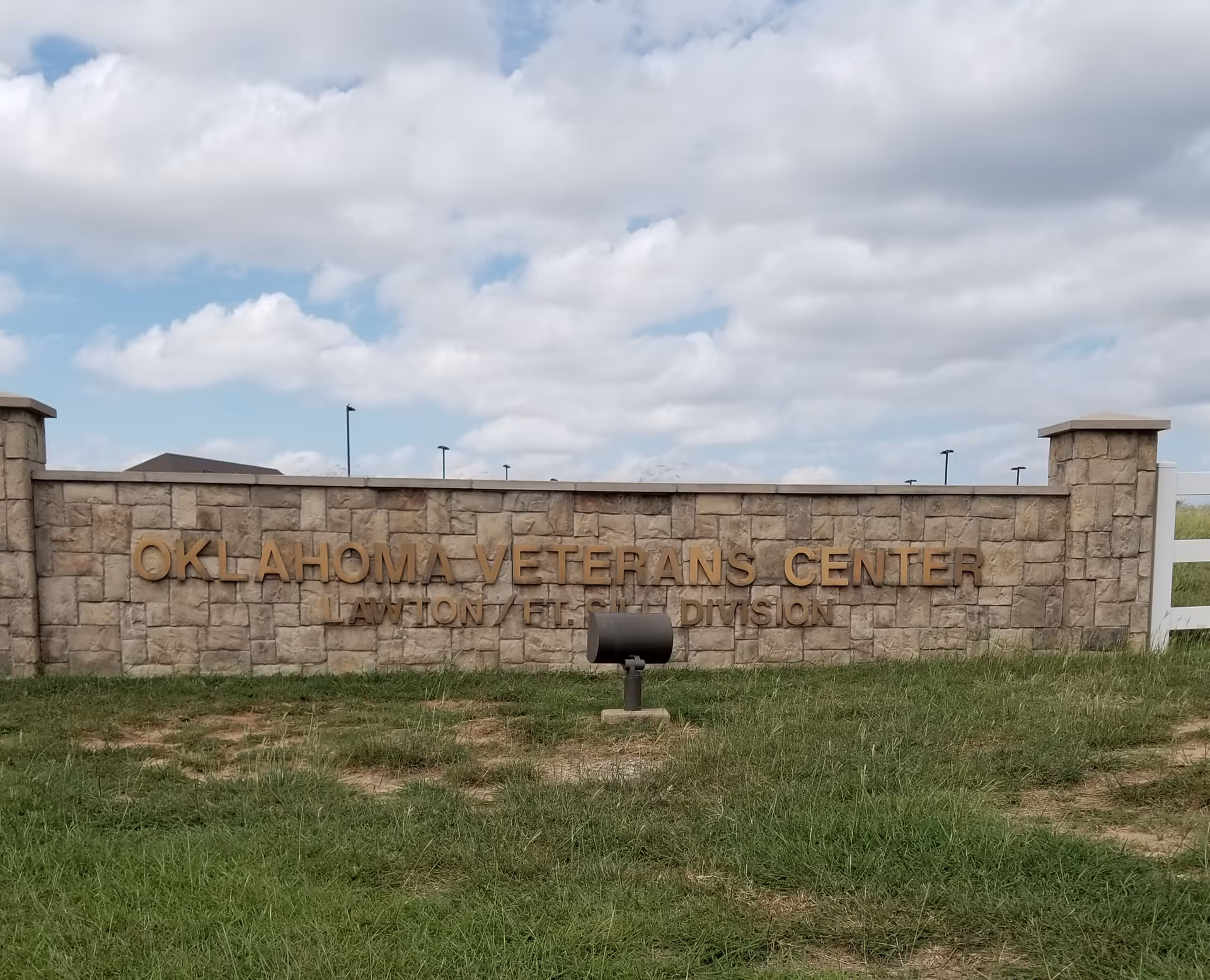 Stone sign wall reads Oklahoma Veterans Center Lawton Fort Sill Division with a grassy foreground