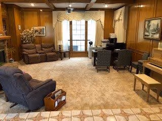 Cozy living room with seating, a piano, and a desk area.