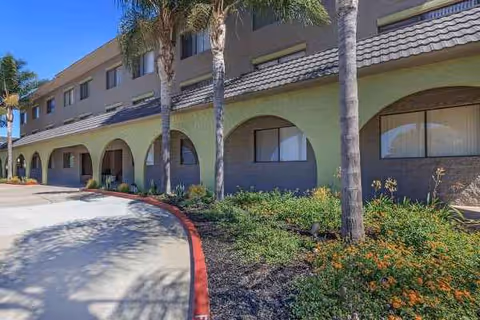 Exterior view of Pacific Pointe facility featuring arches, palm trees, and landscaping.
