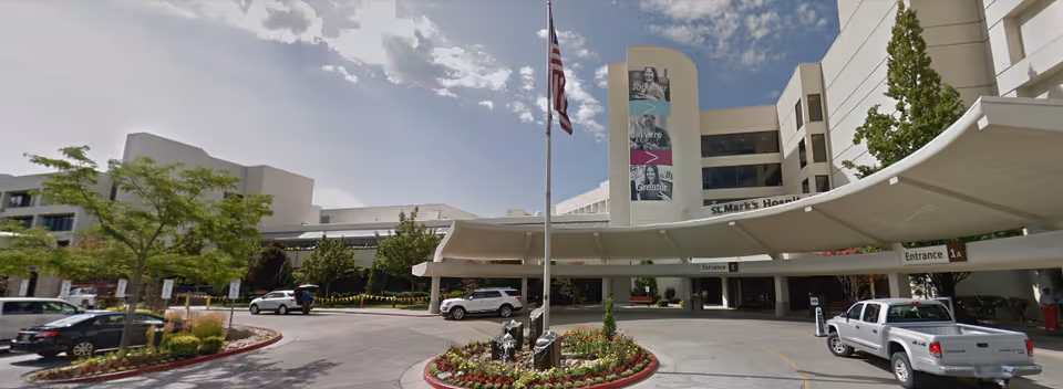 Facility front with curved canopy, flagpole, and circular driveway.