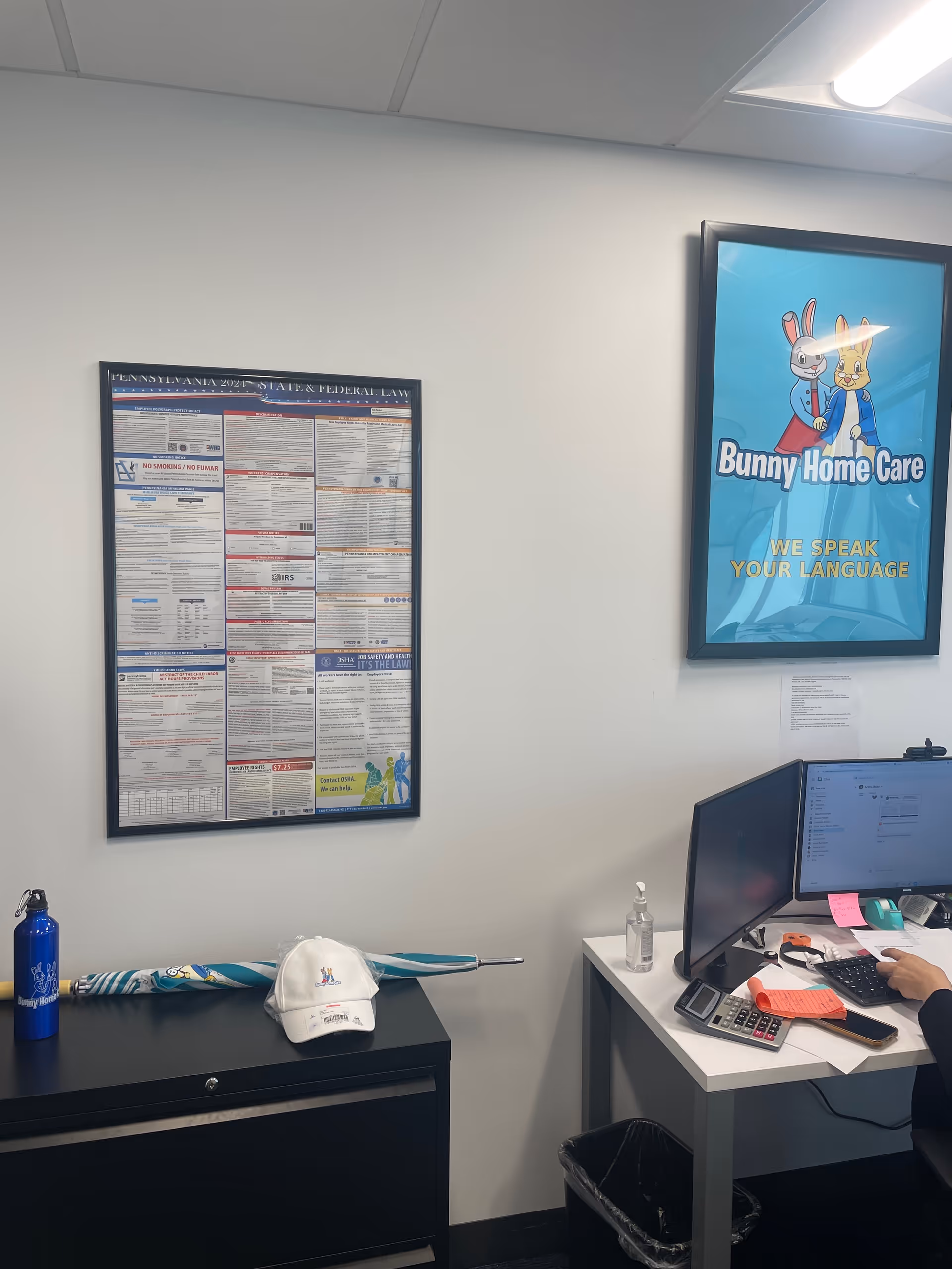 Office corner at Bunny Home Care with a poster, computer monitor, and desk items.