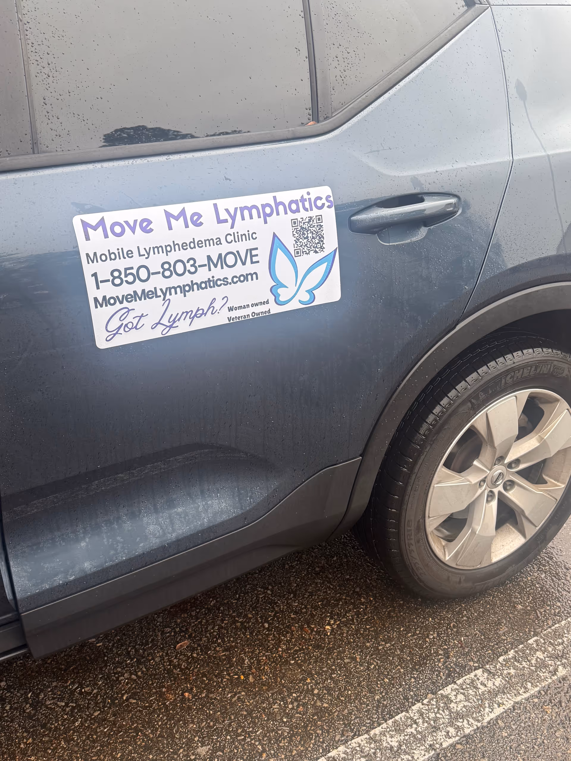 Blue SUV with Move Me Lymphatics mobile clinic sign on door.