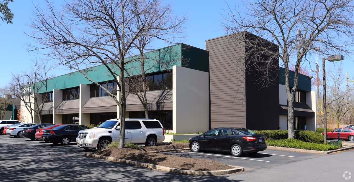 Exterior view of Medihill Medical Alert Systems building with green awnings and parked cars.