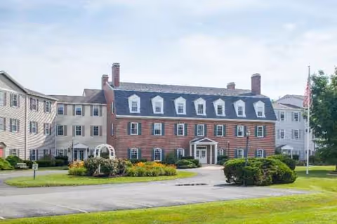 Front exterior view of Langdon Place of Dover, brick facility with wings and landscaped grounds.