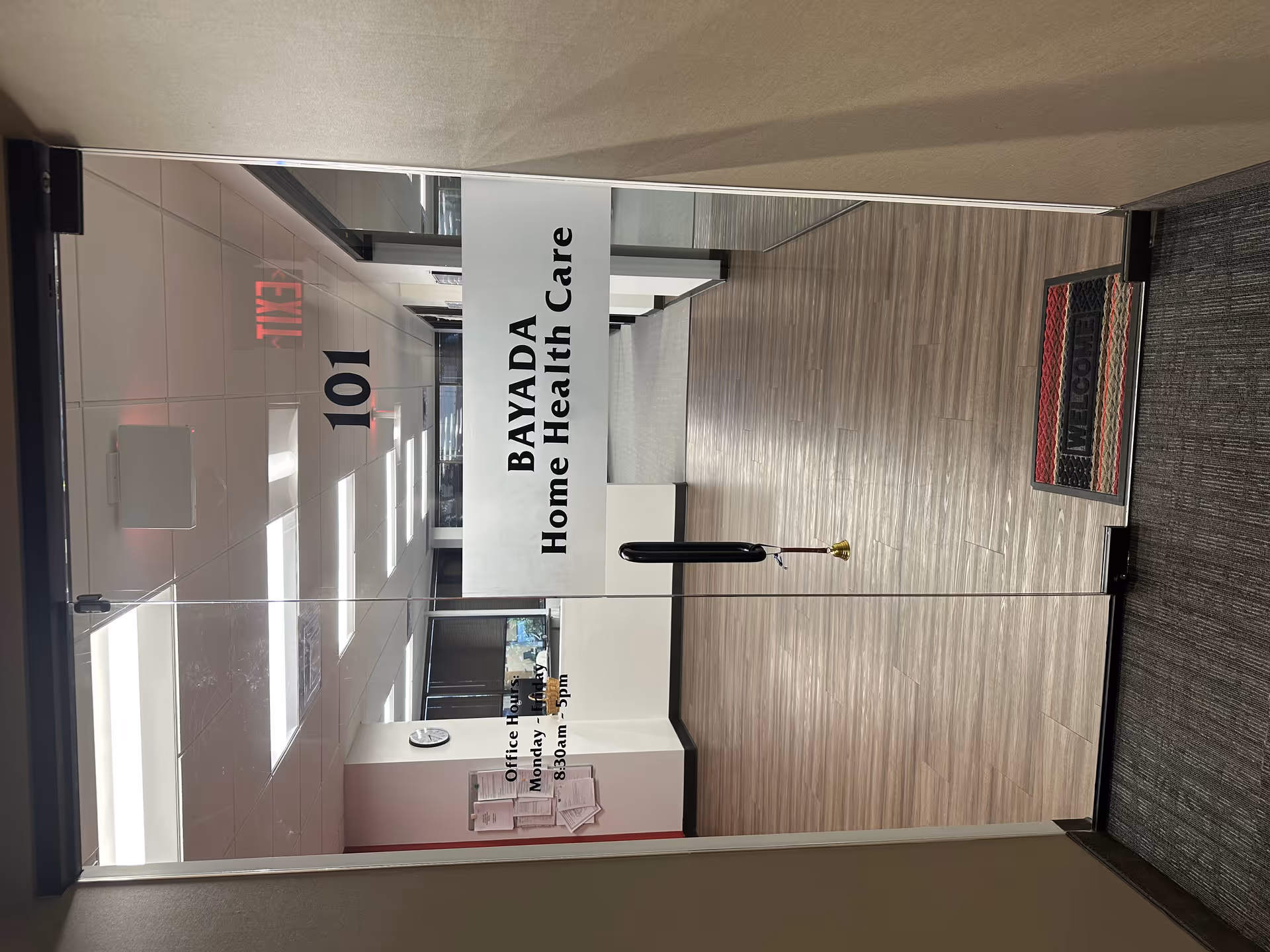 Interior hallway with glass doors reading BAYADA Home Health Care and a welcome mat.