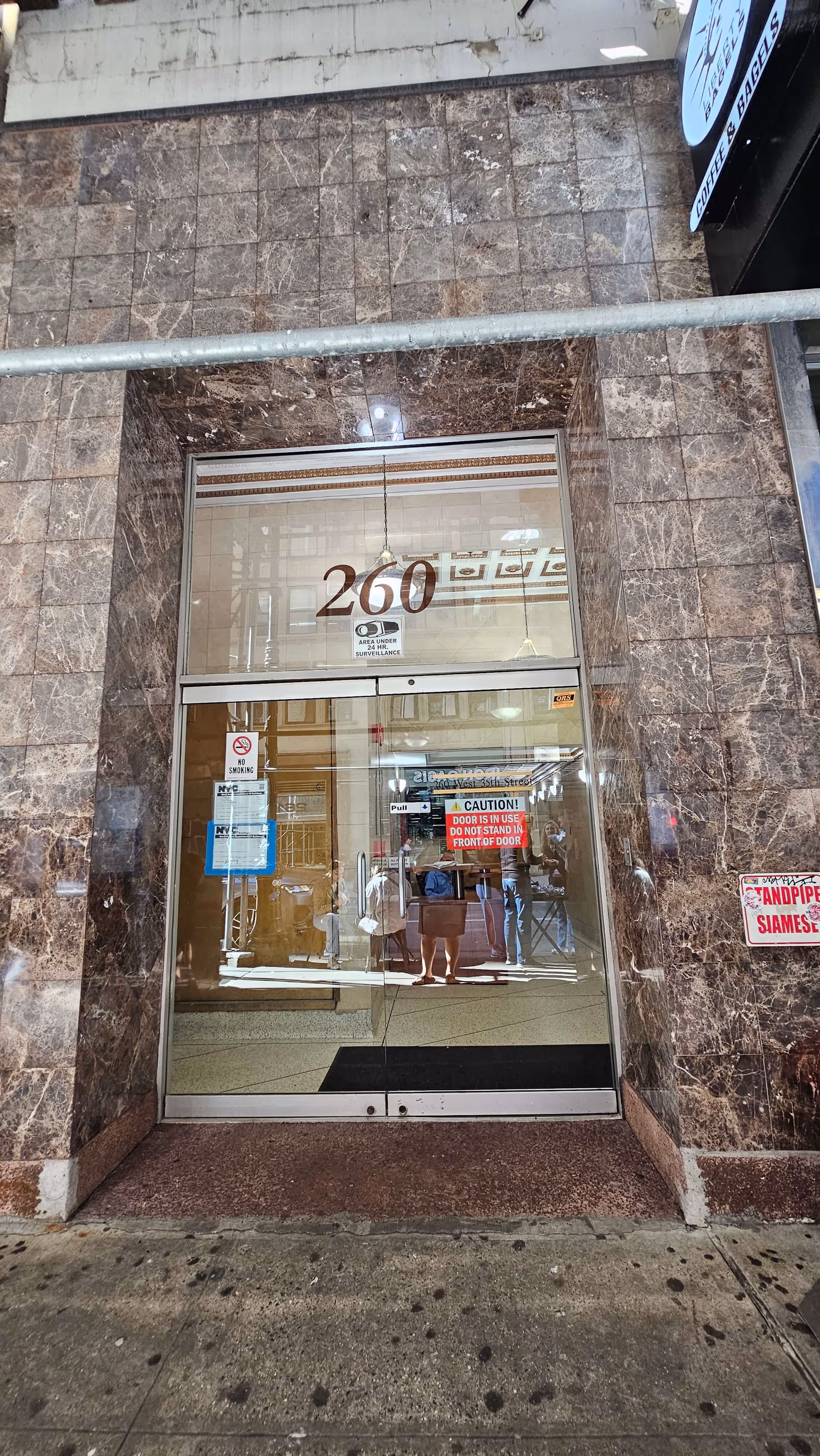 Front entrance of a marble-clad building with glass doors labeled 260.