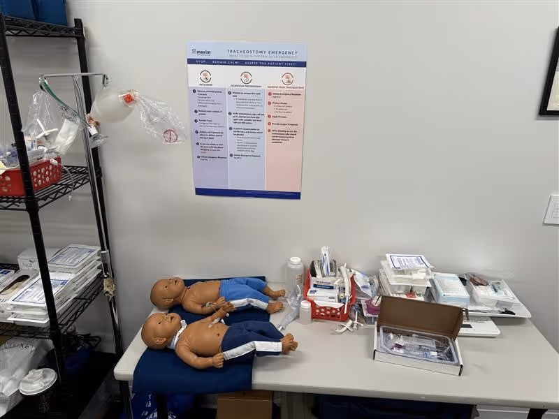 Medical training area with CPR mannequins and medical supplies on a table.