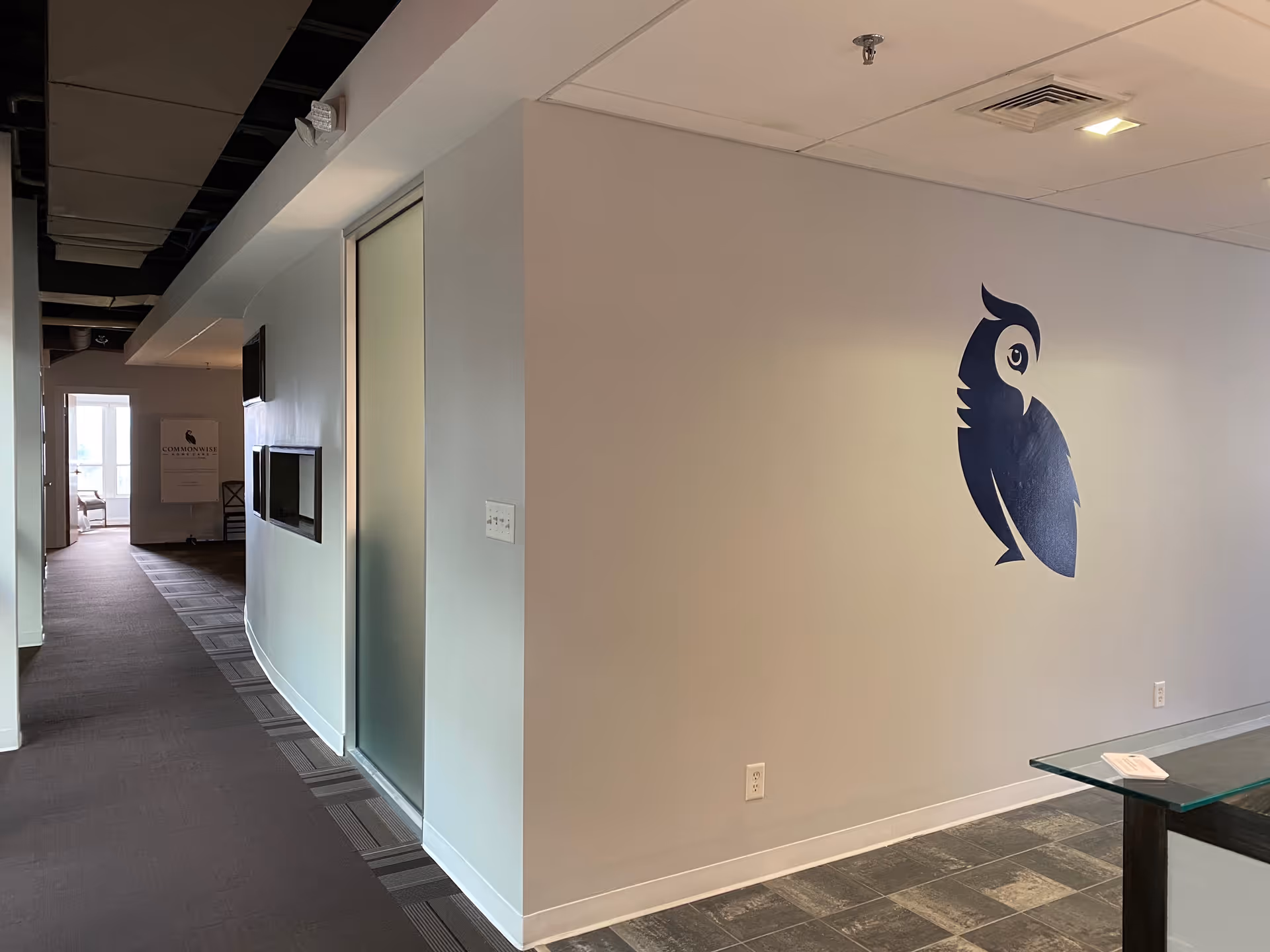 Interior hallway of a senior facility with a large blue parrot mural on the wall.