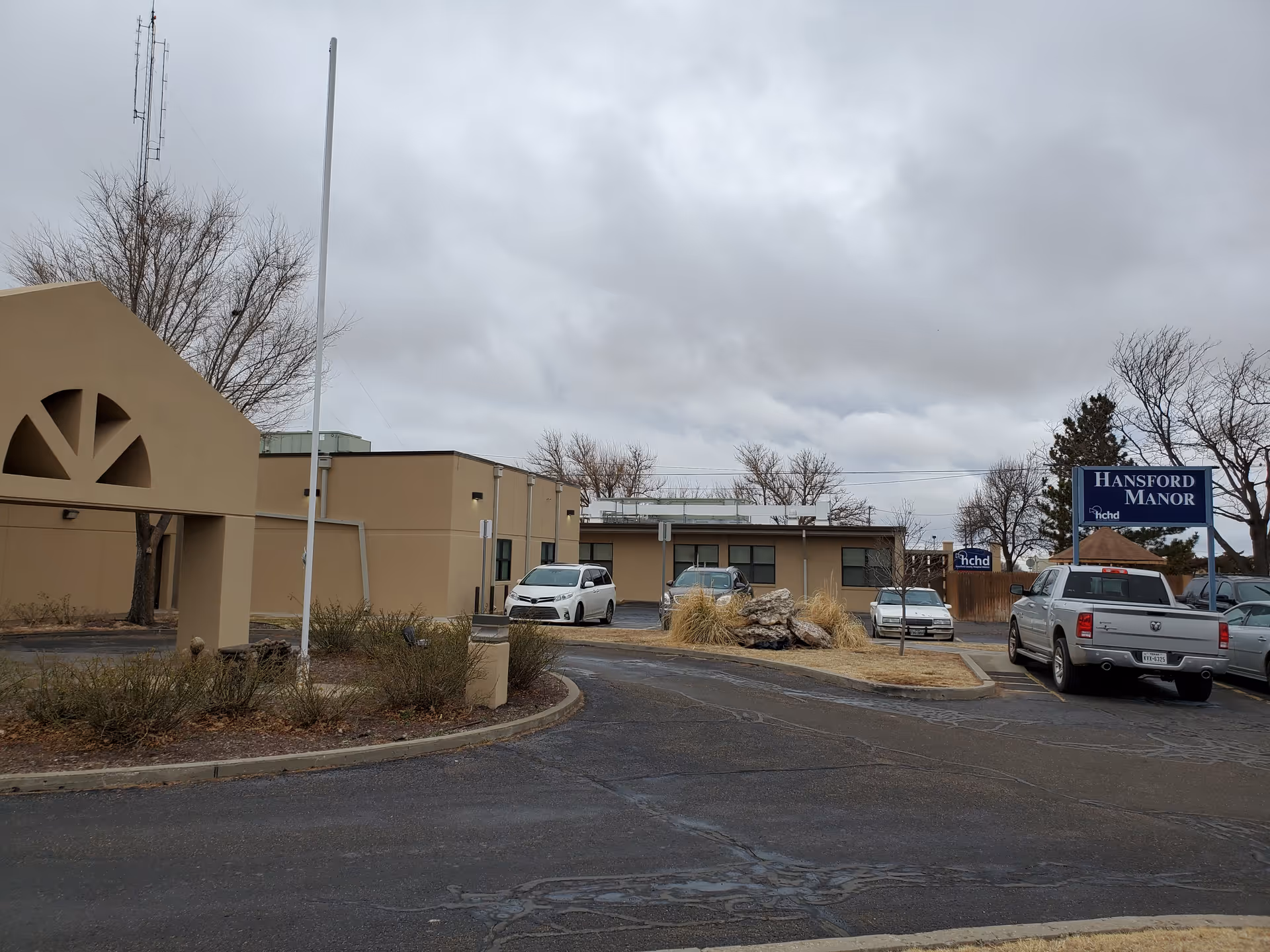 Exterior view of Hansford Manor senior living facility with parking lot and sign.